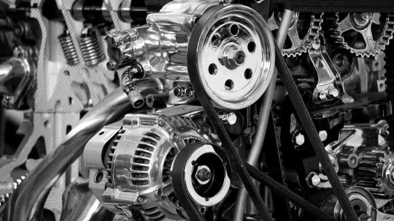 A mobile auto electrician inspecting a faulty alternator under the open bonnet of a car to provide on-site alternator repair in Sheffield.