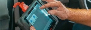 Mobile auto electrician in Sheffield diagnosing an ABS light on dash using professional scanning equipment to clear brake fault codes.