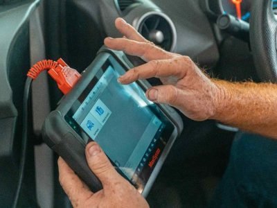 Mobile auto electrician in Sheffield diagnosing an ABS light on dash using professional scanning equipment to clear brake fault codes.