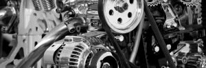 A mobile auto electrician inspecting a faulty alternator under the open bonnet of a car to provide on-site alternator repair in Sheffield.