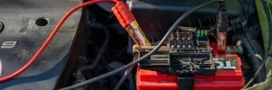A professional battery tester connected to a vehicle battery under the bonnet for mobile car battery replacement services in Sheffield.